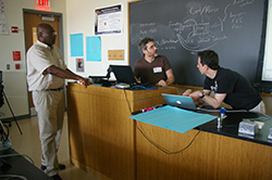 Al Nutile (center) sharing an idea with Gyepi Sam (left) and Peter Wagner (right).